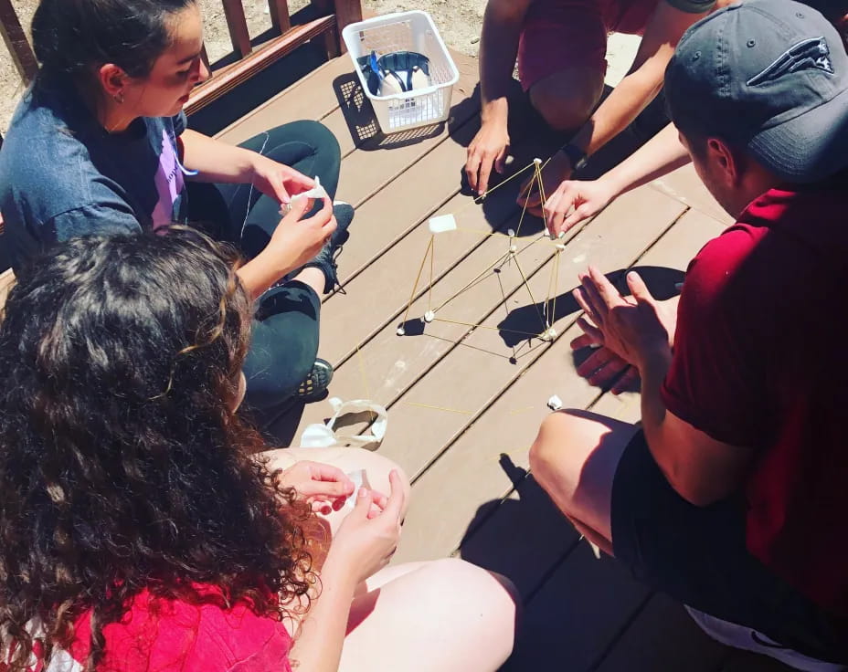 a group of people sitting around a table playing a game