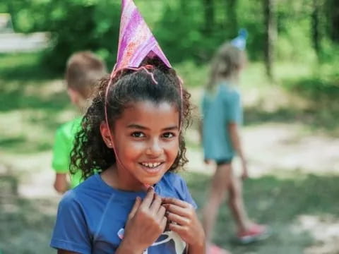 a young girl wearing a party hat