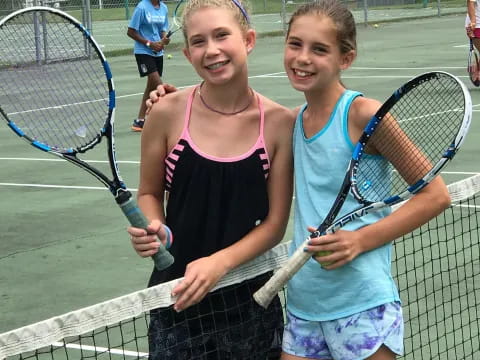 girls holding tennis rackets