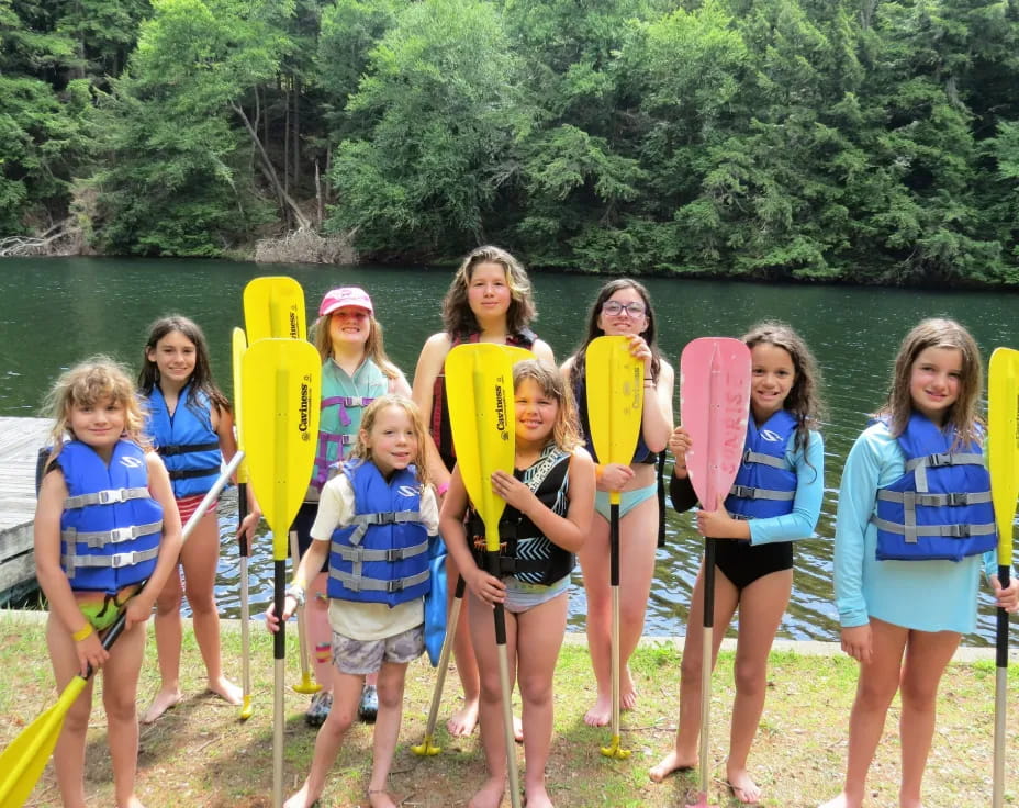 a group of girls holding paddles