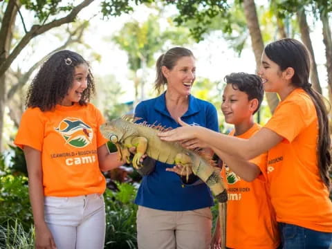 a group of kids holding a large reptile