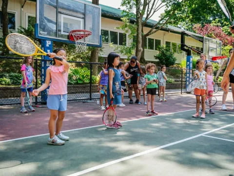 a group of kids playing tennis