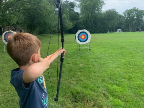 a boy shooting a bow and arrow