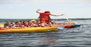 a group of people in a row boat on water