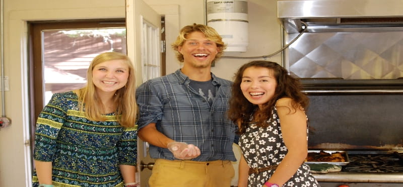 a group of people posing for a photo in front of a stove