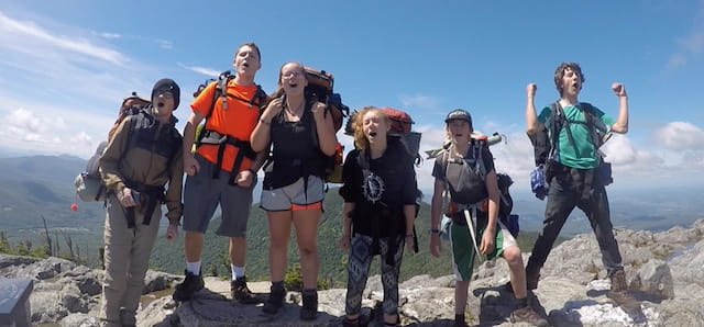 a group of people posing for a photo on a mountain