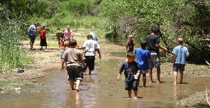 a group of people walking through a flooded area
