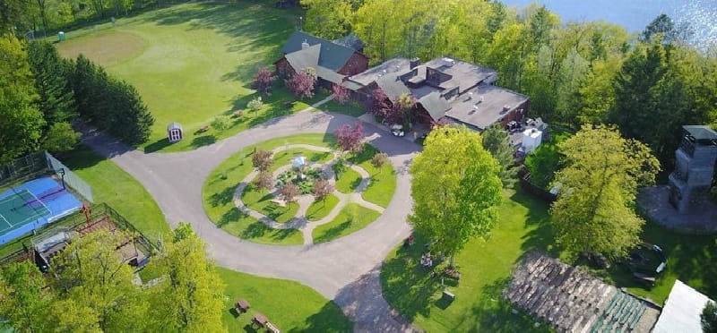 a large house with a lawn and trees around it