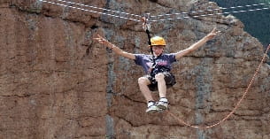 a man wearing a helmet and climbing a rock wall