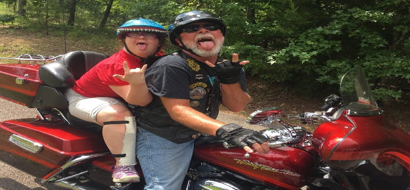 a person and a child on a red motorcycle