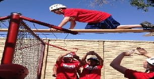 a person jumping over a red metal structure