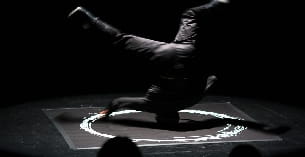 a person kneeling on the ground with a fire in their hands