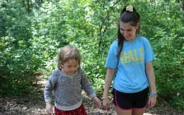 a person and a child walking in the woods