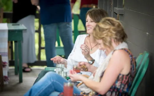 a woman sitting next to another woman