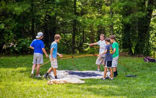 a group of people playing with a net on a grass field