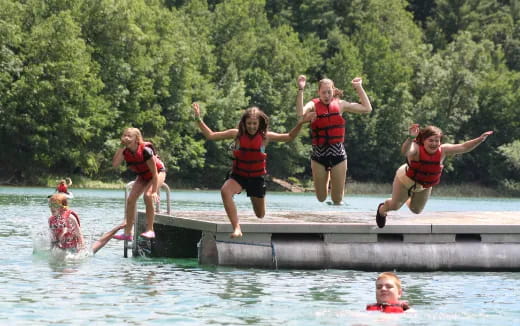 a group of children jumping into water