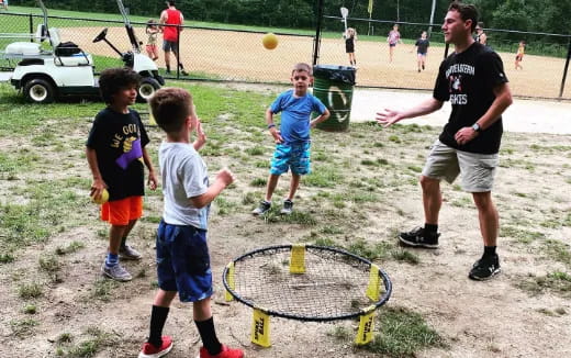a person and kids playing tennis