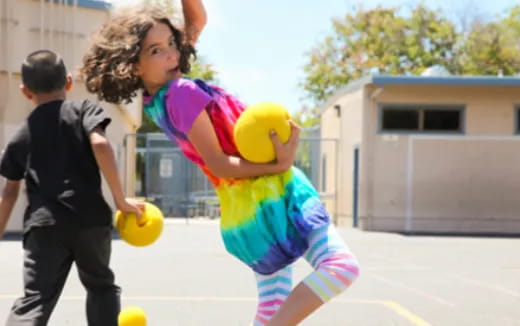 a girl holding a ball