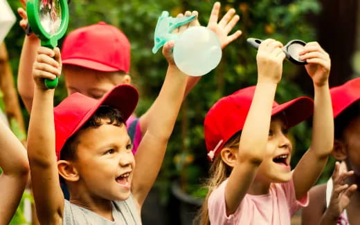a group of children holding up plastic bottles