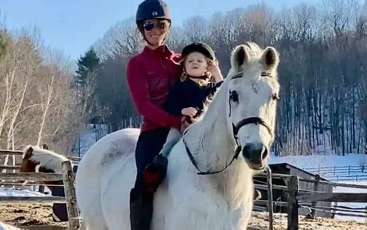 a person and a child riding a horse