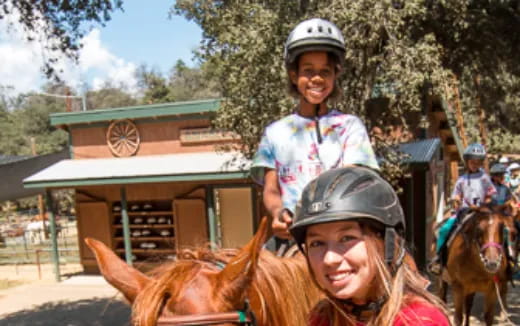 a person riding a horse with a child on the back