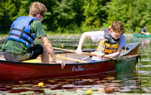 a couple of men in a canoe