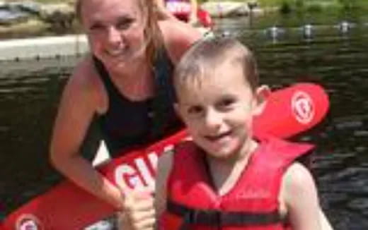 a person and a boy in a red boat