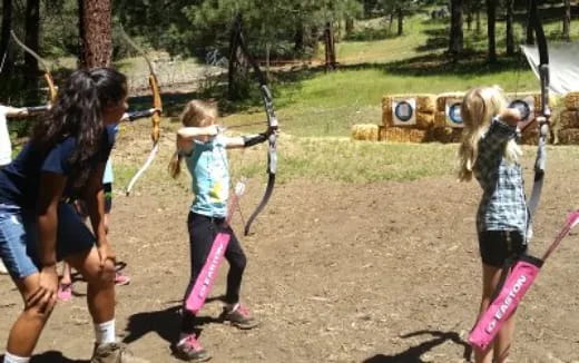 a group of people playing with bows and arrows