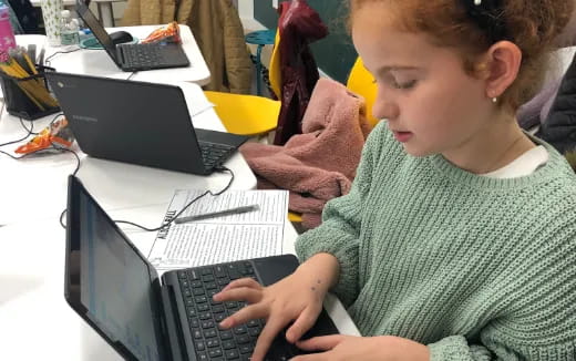 a young girl using a laptop