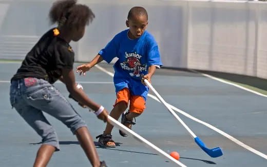 a boy and a girl playing hockey