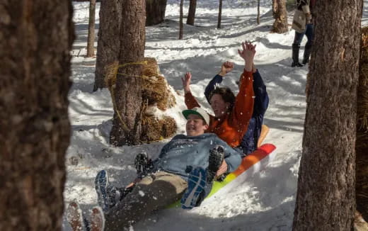 a couple of people on a sled in the snow