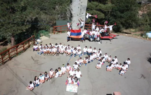 a large group of people sitting on a concrete ledge