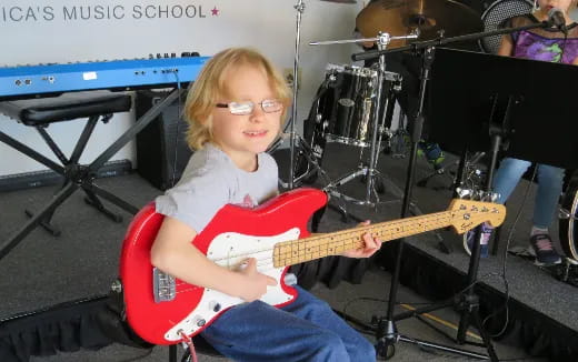 a young girl playing a guitar