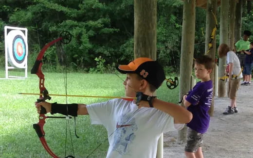 a boy shooting a bow and arrow