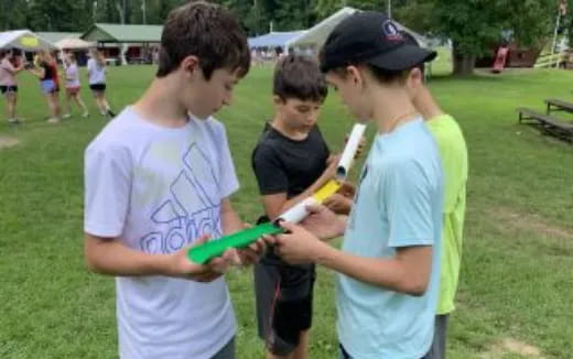 a group of boys playing with a toy gun