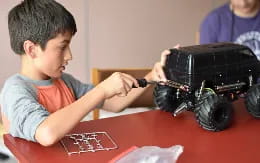 a boy playing with a toy car