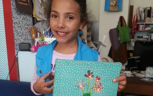 a girl holding a drawing