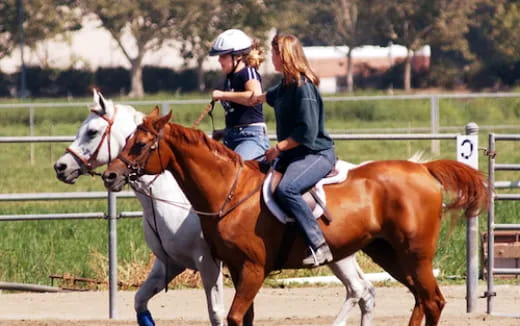 a couple of women riding horses