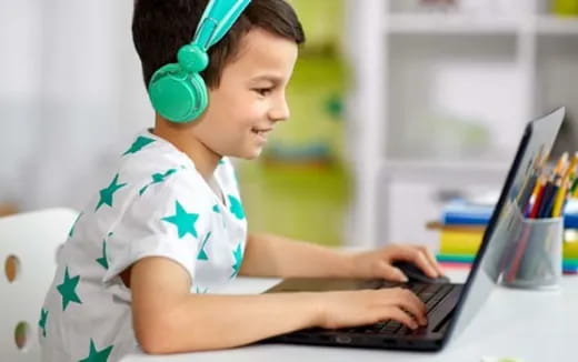a young boy using a laptop