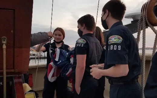a group of people standing next to a boat