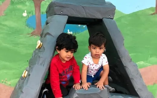 a couple of children in a green slide