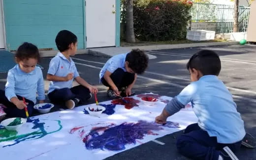 a group of kids painting on the ground