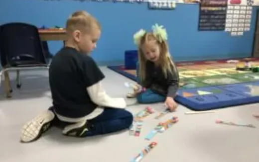 a boy and girl sitting on the floor