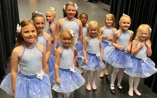 a group of girls in blue dresses