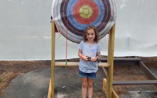 a girl standing next to a sign