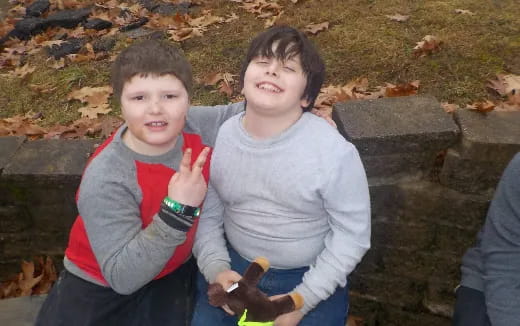 a couple of children sitting on a stone bench