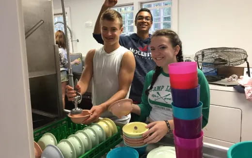 a group of people standing around a table with food