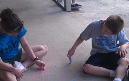 a few boys painting on the ground