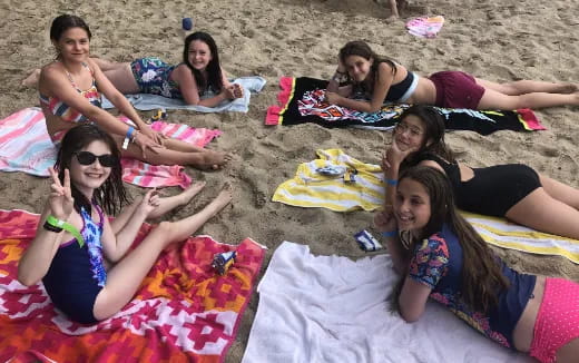 a group of women lying on a beach