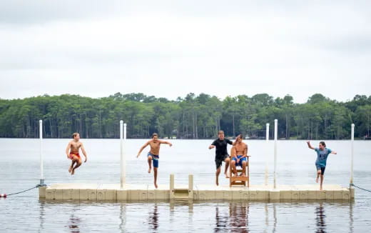 a group of people jumping into the water